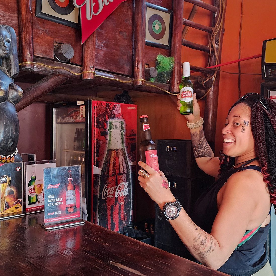 Smiling bartender serving cold beers at a wooden beach bar