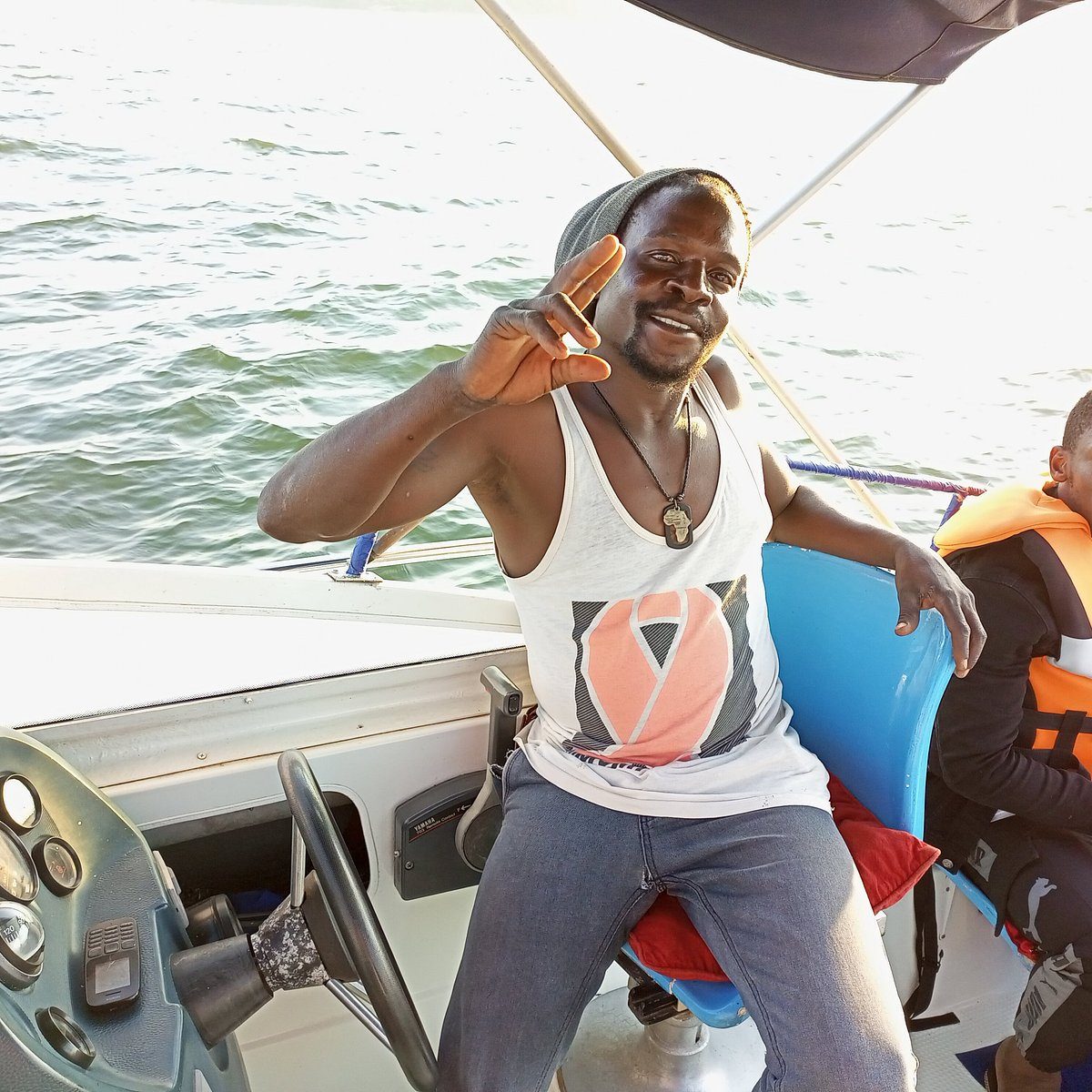 Smiling boat captain flashing a peace sign on a Lake Victoria cruise