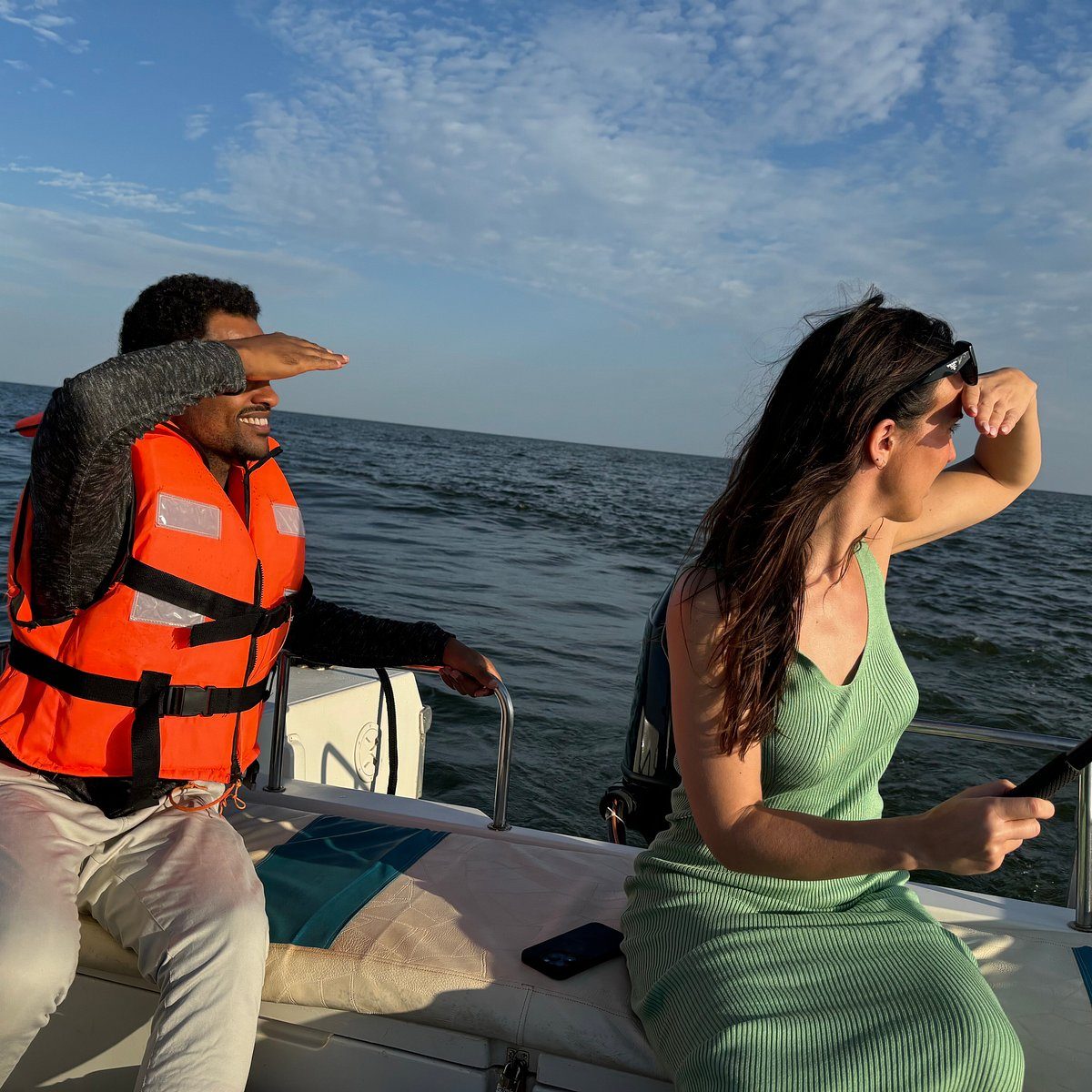 Two friends in a life jacket enjoying a golden hour boat ride on Lake Victoria